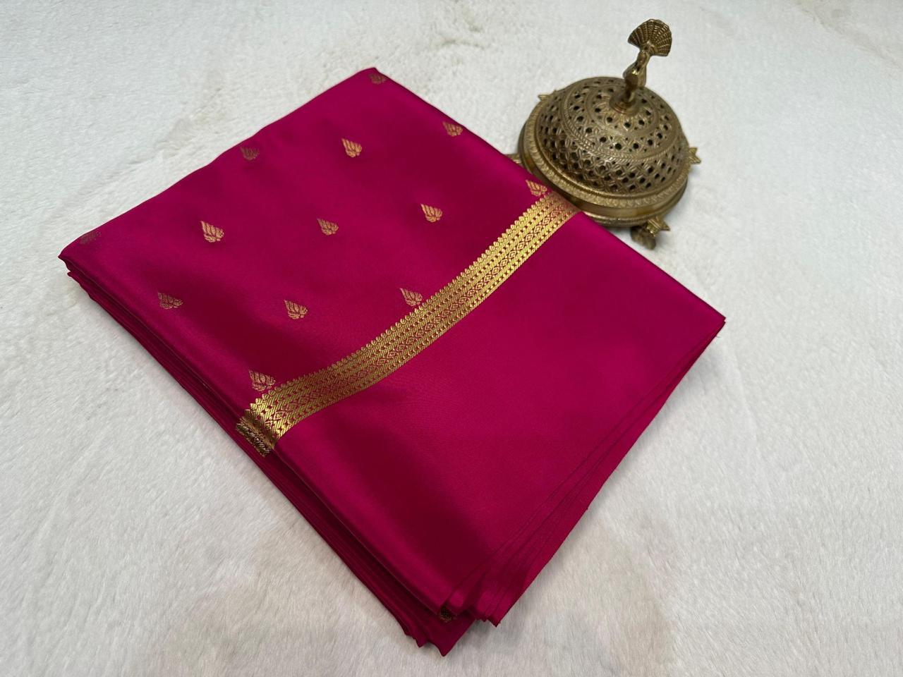 Red saree with gold border and decorative item on a white background